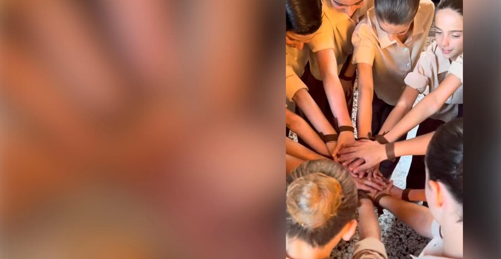 Gruppo di ragazze in divisa beige che uniscono le mani in segno di unità.